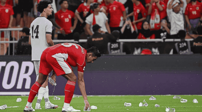 Cổ động viên quá khích Indonesia ném chai lọ, cốc nhựa xuống sân để phản đối trọng tài (Ảnh: Bola).