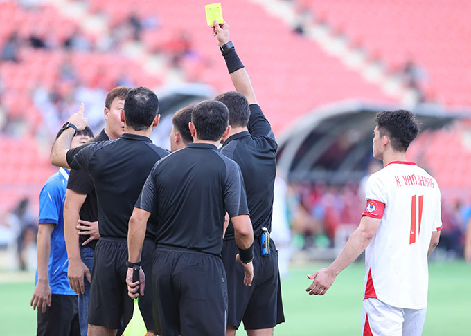 HLV Kim Sang Sik bị phạt thẻ vàng - Ảnh: Đức Cường
