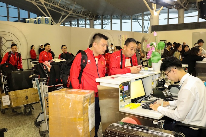Các thành viên đoàn thể thao làm thủ tục tại sân bay Nội Bài - Ảnh: Bùi Lượng