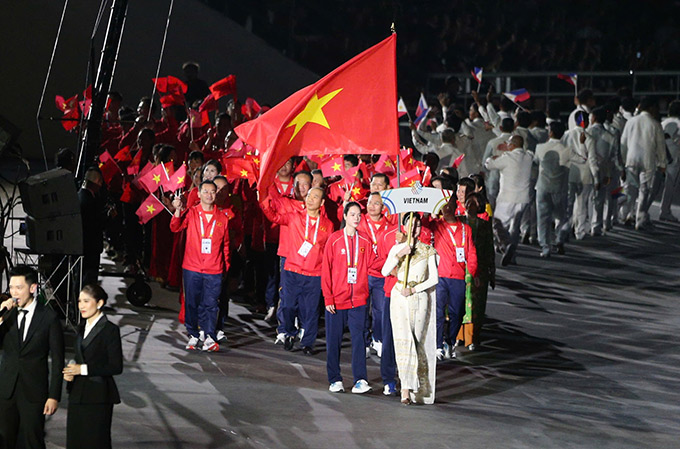  VĐV Lê Minh Thuận (taekwondo) và Lê Thanh Thúy (bóng chuyền) vinh dự cầm cờ cho Việt Nam trong lễ khai mạc - Ảnh: Đức Cường