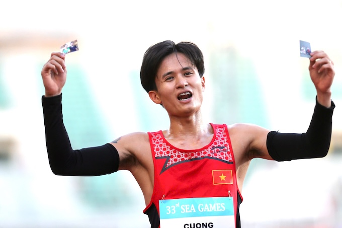 Nguyễn Trung Cường khoe ảnh bố mẹ khi cán đích nội dung 3.000m vượt chướng ngại vật của nam. Ảnh: Khả Hoà