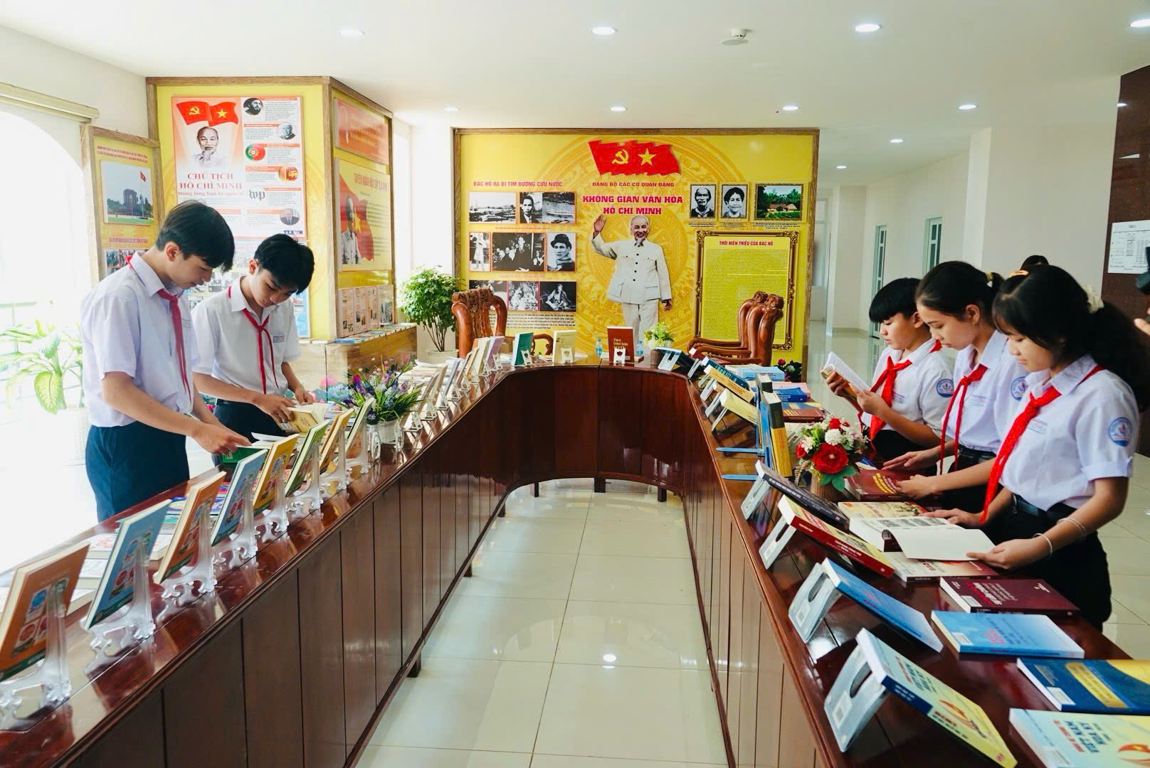 Các em học sinh tham quan và tìm hiểu các ấn phẩm sách trao tặng được trưng bày tại không gian văn hoá Hồ Chí Minh (trung tâm hành chính xã Bắc Tân Uyên)