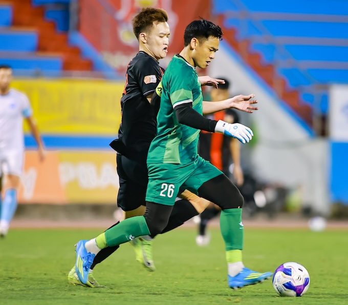 Hoàng Đức tranh bóng cùng thủ môn Nguyên Mạnh trong trận giao hữu giữa Ninh Bình và Nam Định. Ảnh: Quang Dương