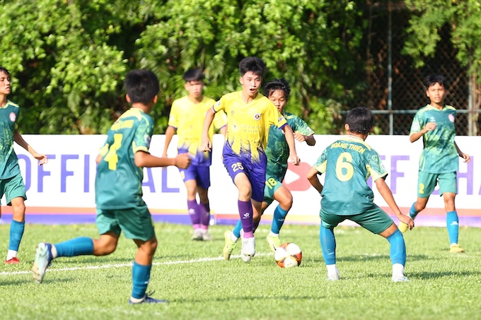 Cầu thủ Hà Nội I (áo vàng) trong vòng vây của đội Đắk Lắk. Ảnh: Nguyễn Khánh 