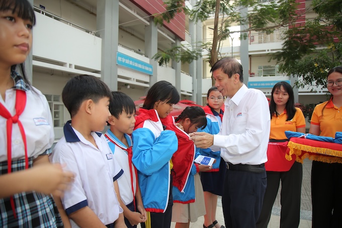 Quyền Tổng biên tập báo SGGP Nguyễn Đắc Văn trao áo ấm cho các học sinh vào sáng 7/4. Ảnh: Dũng Phương 
