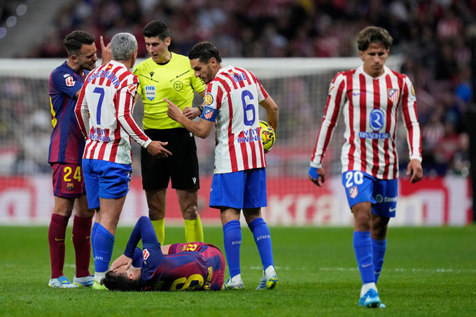 Pedri (nằm) bị đau ở trận đấu giữa Barca và Atletico