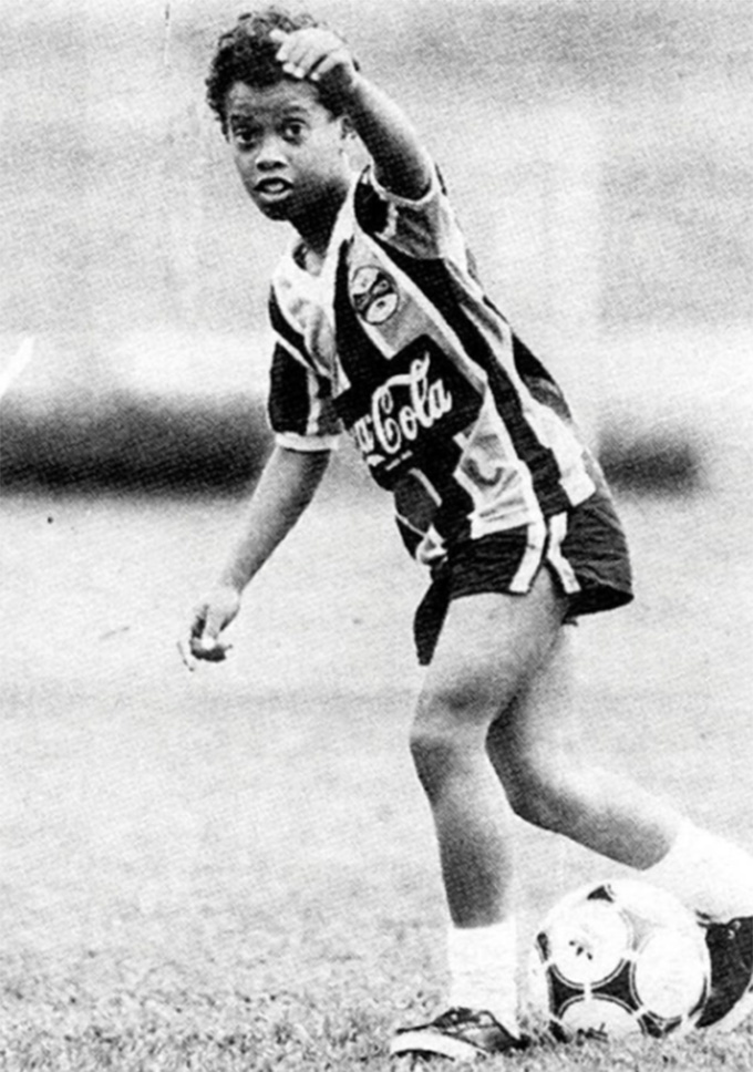 Ronaldinho hồi nhỏ, mặc áo đấu của Grêmio, với trái bóng đã dính chặt vào chân