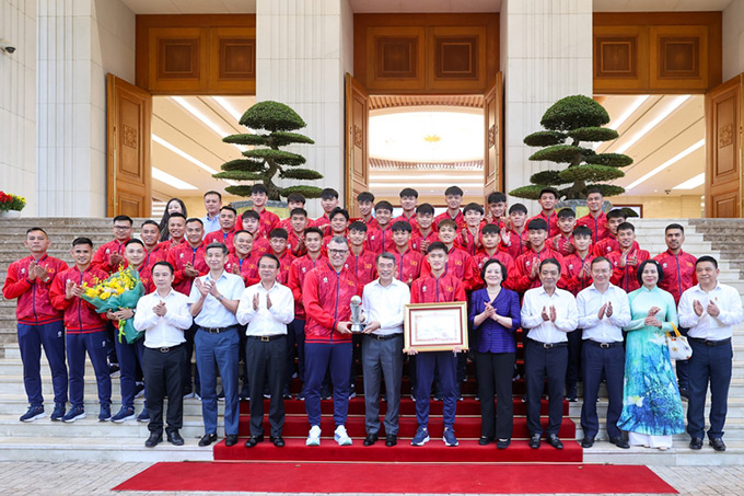Thủ tướng chụp ảnh lưu niệm cùng đội tuyển - Ảnh: Báo Chính phủ 