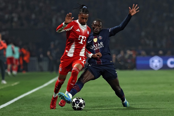 Michael Olise tranh bóng với Nuno Mendes tại bán kết lượt đi Champions League giữa PSG và Bayern (5-4)