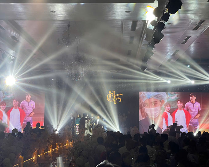 Không gian tiệc cưới được đầu tư hoành tráng với hệ thống ánh sáng sân khấu, màn hình LED lớn và lối đi trang trí lãng mạn, tạo nên khoảnh khắc ấn tượng trong ngày trọng đại của cặp đôi.