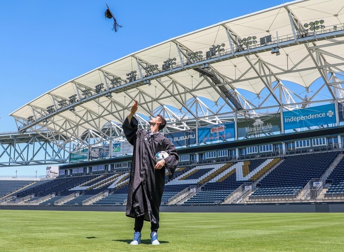 Matt Freese trong bộ đồ cử nhân Harvard tại sân bóng đá. Ảnh: Instagram
