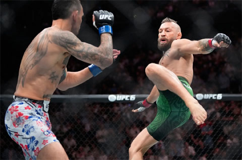 McGregor (phải) tung đòn đá trong trận đấu với Max Holloway tại UFC 329. Ảnh: AP