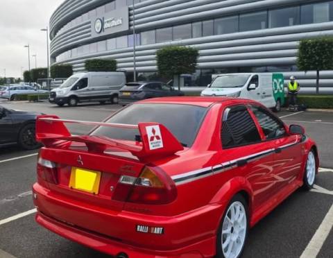 Mitsubishi Lancer Evolution VI màu đỏ, nổi bật trước cửa sân Etihad của Man xanh