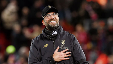 HLV Klopp ôm cầu thủ Benfica động viên, đặt tay lên ngực trái ăn mừng cùng CĐV Liverpool